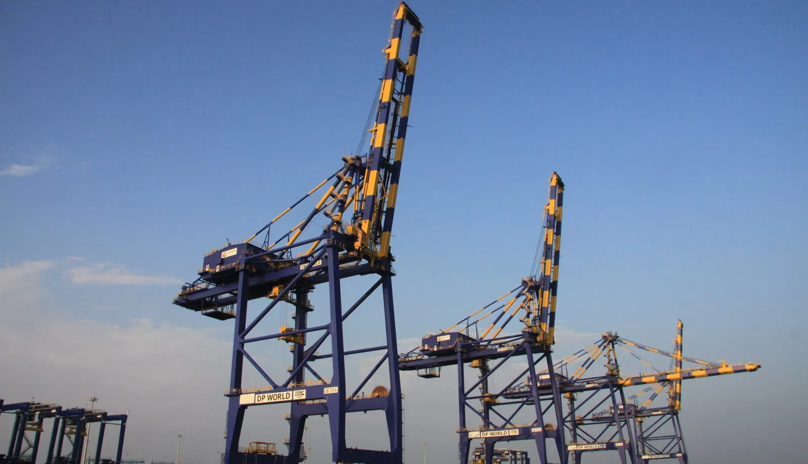Container terminal gantry cranes silhouetted against the sunset in India.