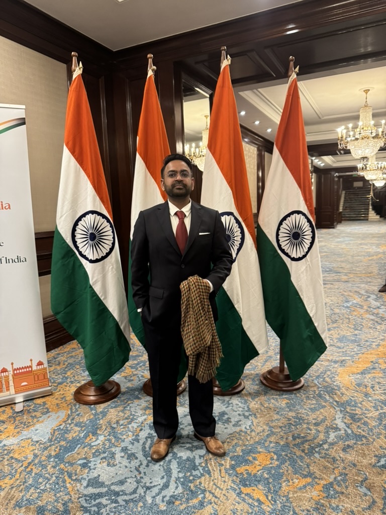 Sushaantu at the reception, with Indian flags behind him.